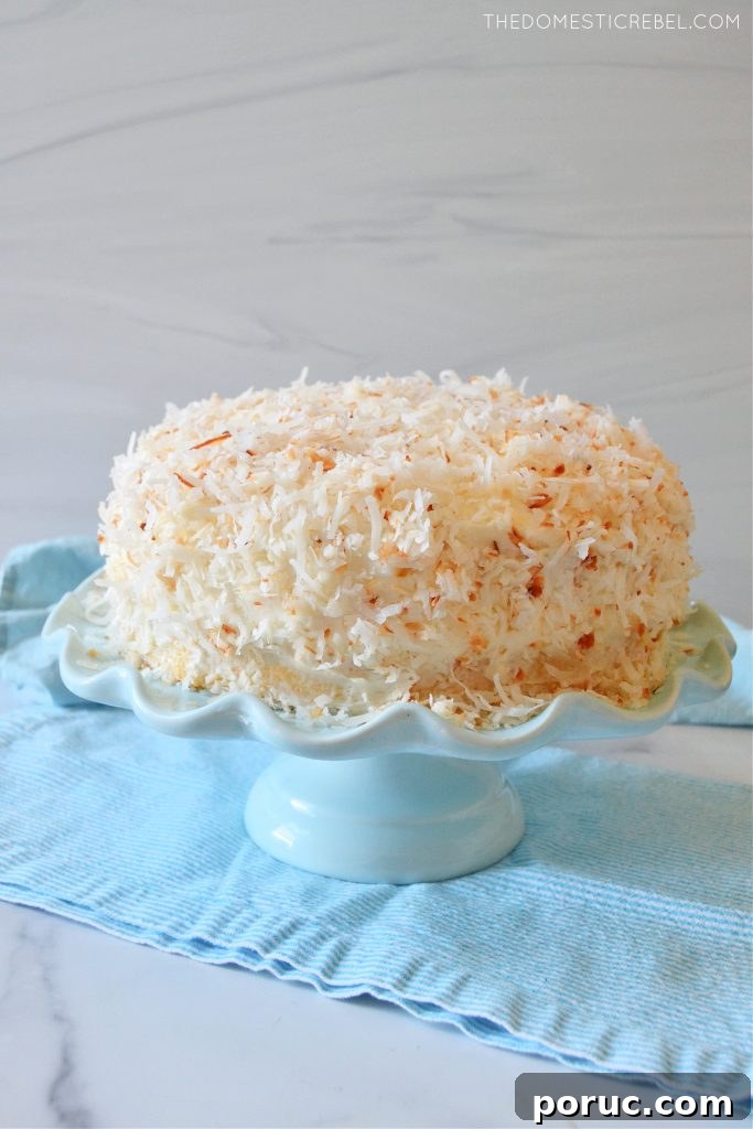 Ultimate Coconut Layer Cake Recipe for Moist, Classic Flavor 3 coconut layer cake on a blue cake stand