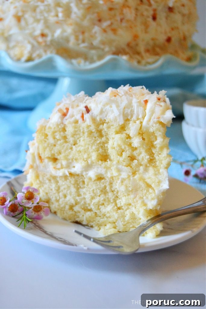 Ultimate Coconut Layer Cake Recipe for Moist, Classic Flavor 7 coconut layer cake with a fork on a plate