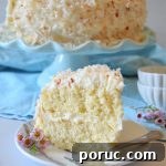 Ultimate Coconut Layer Cake Recipe for Moist, Classic Flavor 8 a slice of coconut layer cake on a white plate