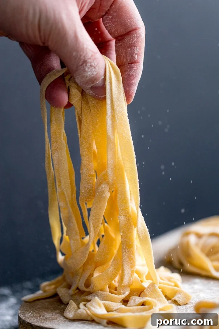 homemade tagliatelle being lifted off a board