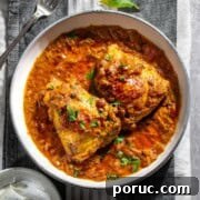 Authentic Nepali Chicken Curry Recipe: Traditional Taste Guide 9 Two pieces of Nepalese chicken curry in a white bowl on a grey and white tea towel.