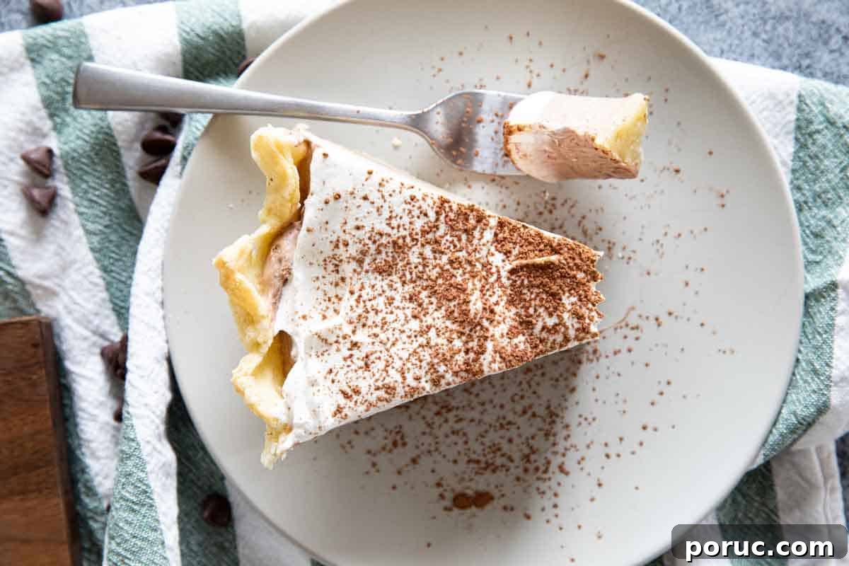 Rich, creamy and silky, this Chocolate Cream Pie is a chocolate lovers dream! A creamy chocolate filling is topped with whipped cream in this easy, crowd pleasing pie. overhead view of slice of chocolate cream pie