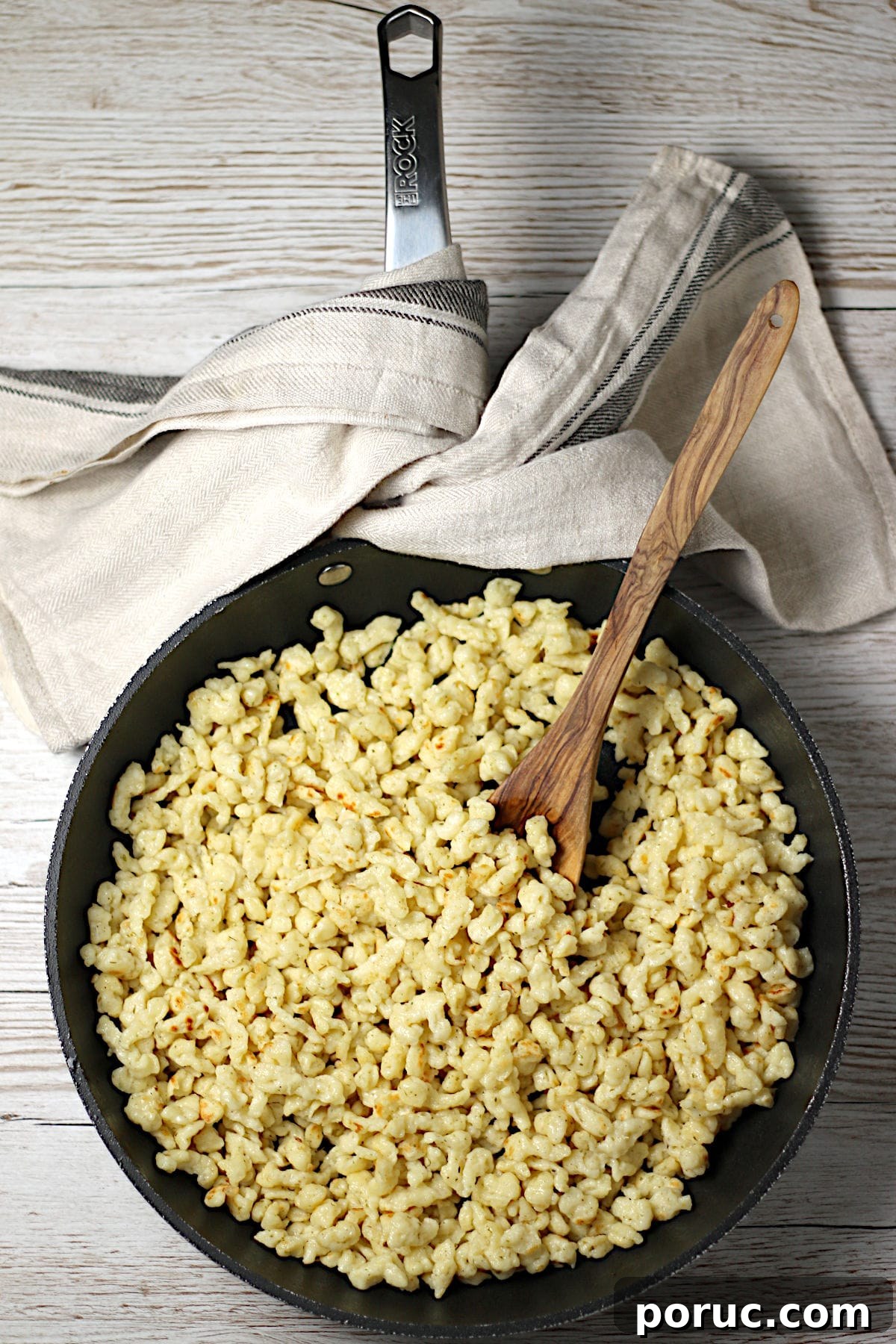 Authentic German Spaetzle Recipe: Step-by-Step Homemade Spaetzle 2 Spaetzle in a large skillet with a wooden spoon.
