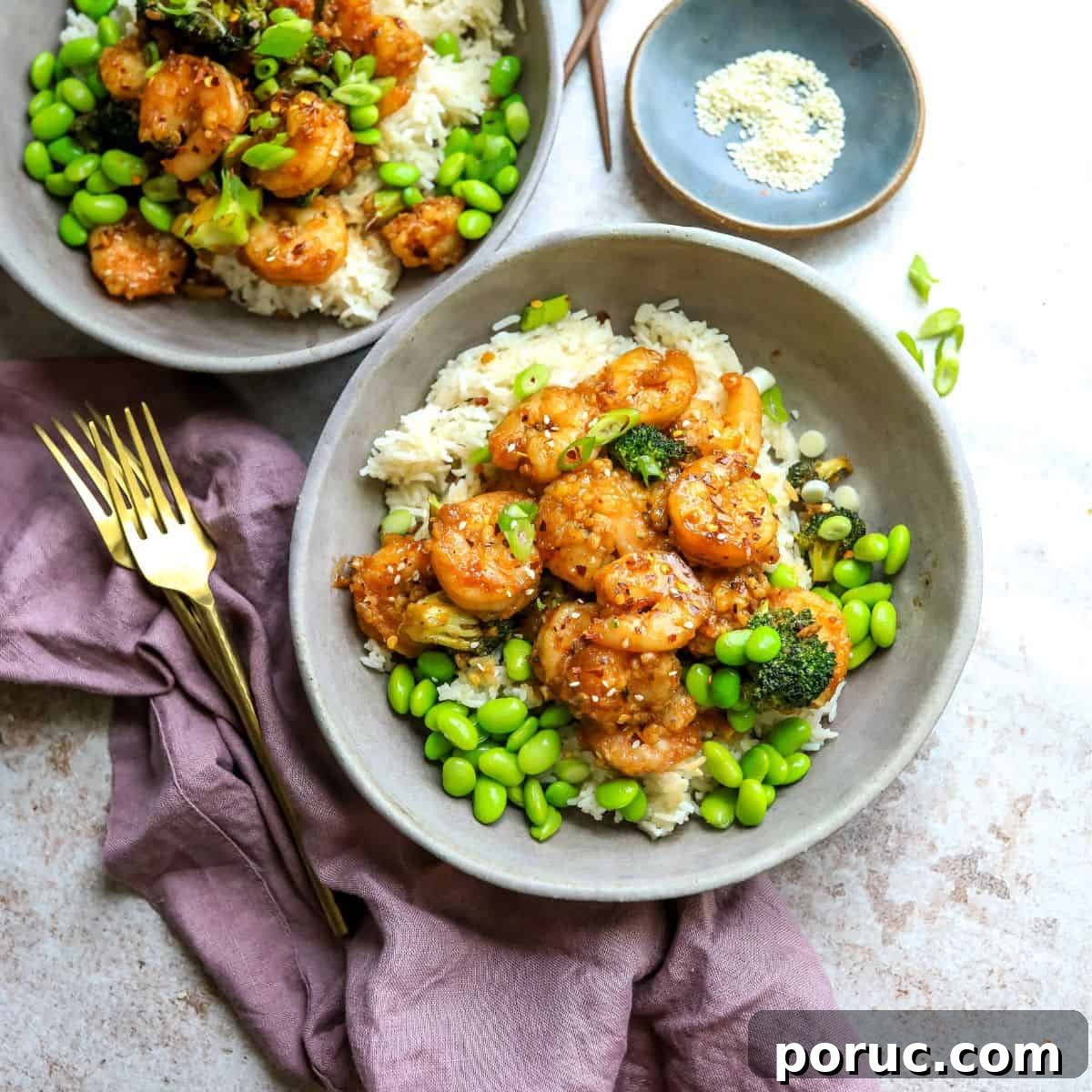 Mongolian Shrimp and Broccoli Stir-Fry Recipe 2 Grey ceramic bowls with rice and Mongolian shrimp with gold forks.