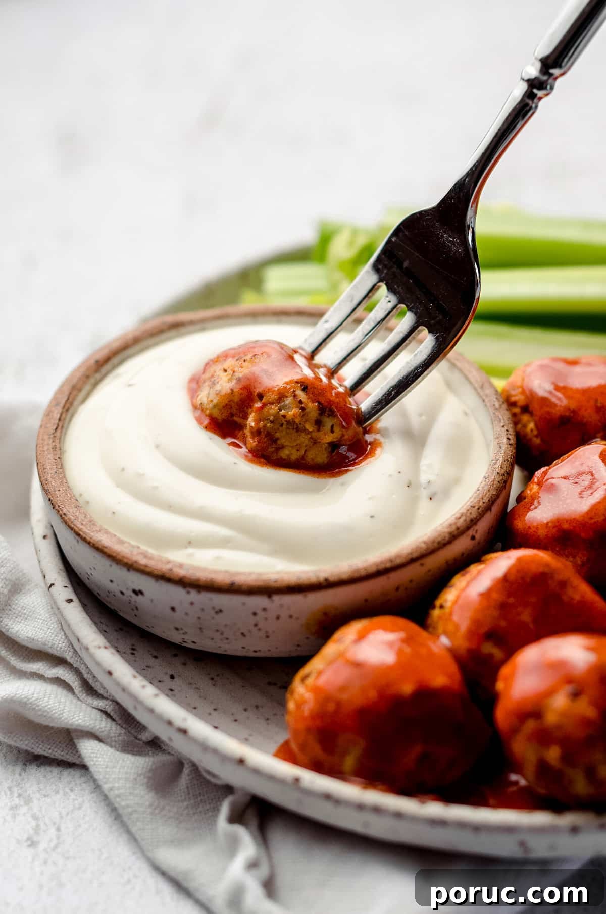 Dipping a meatball into a creamy sauce.