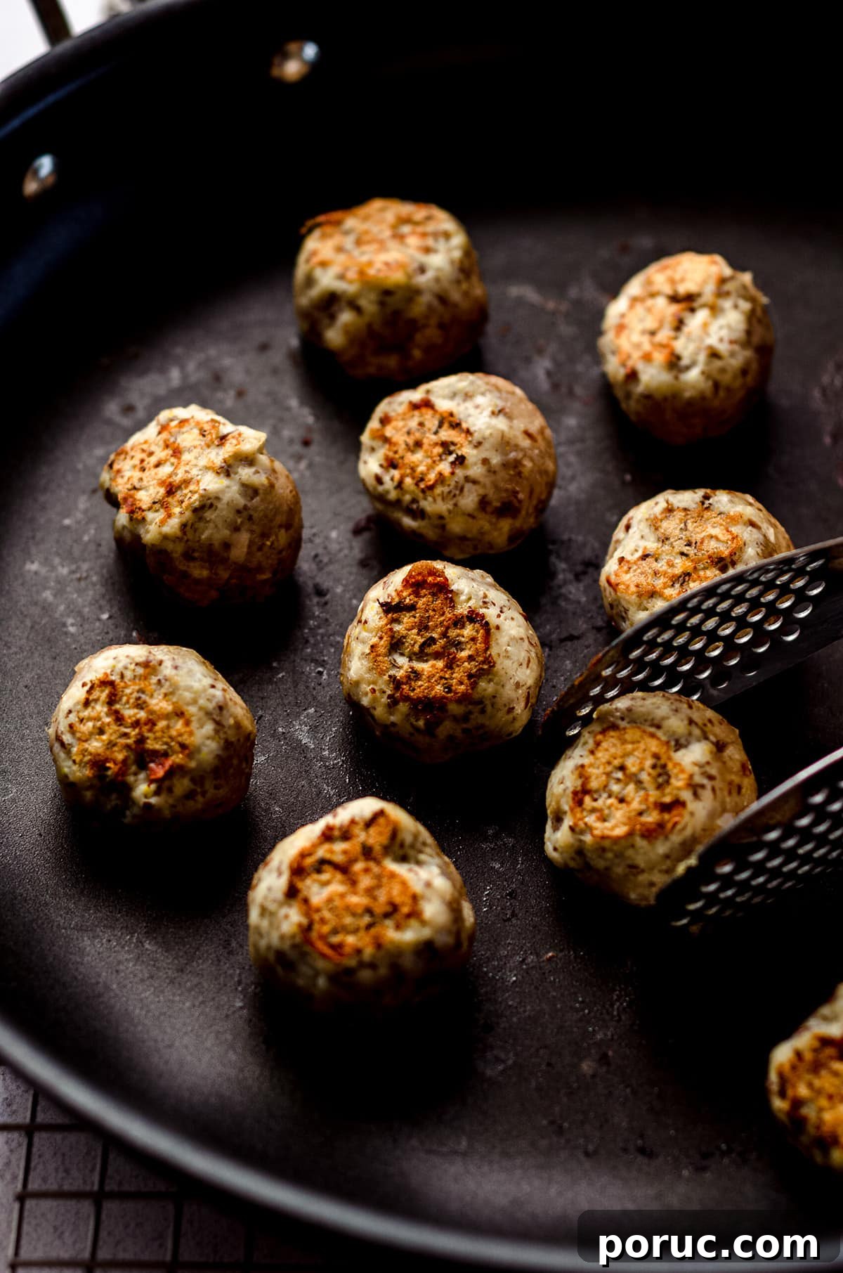 Browning meatballs in a cast iron skillet.
