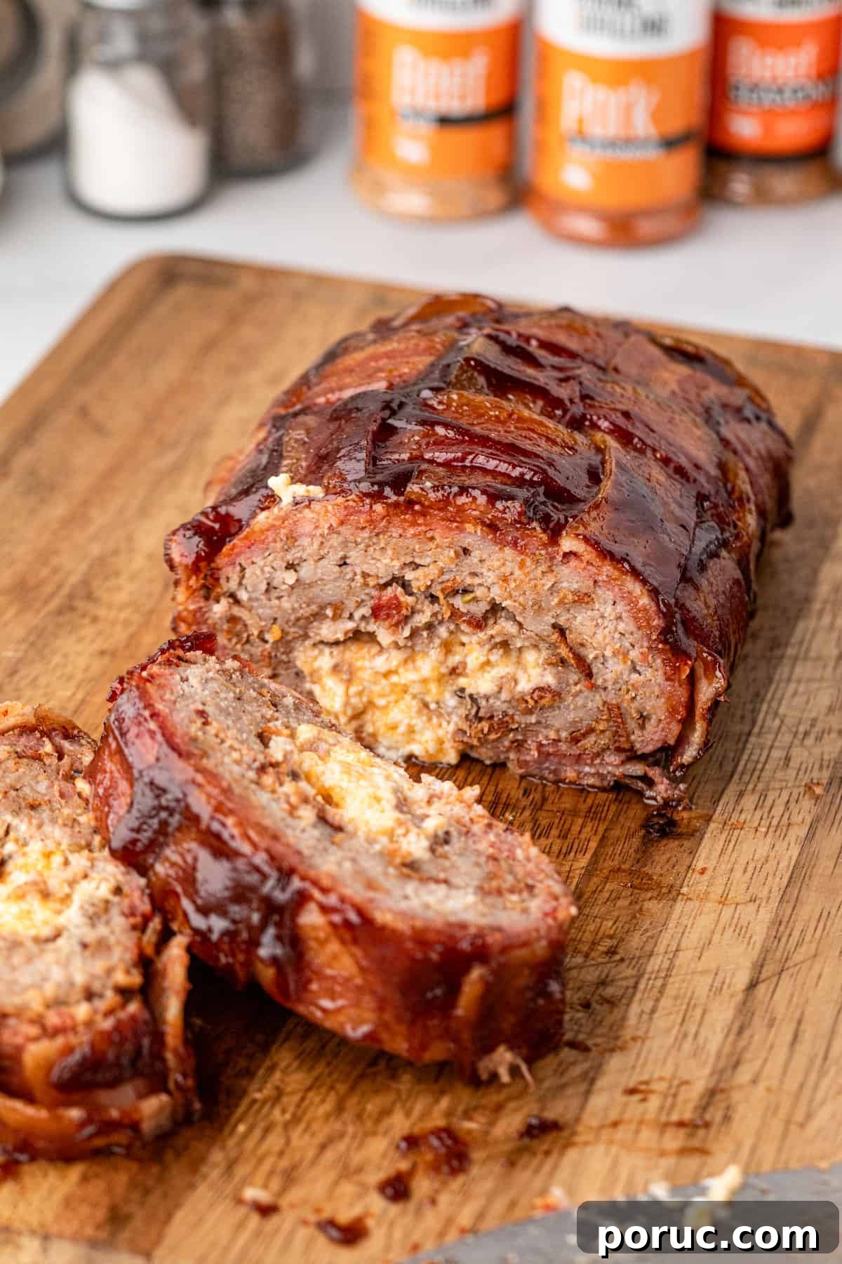 Ultimate Bacon Explosion Recipe: Stuffed Bacon-Wrapped Meatloaf 2 Bacon Explosion sliced on wooden cutting board
