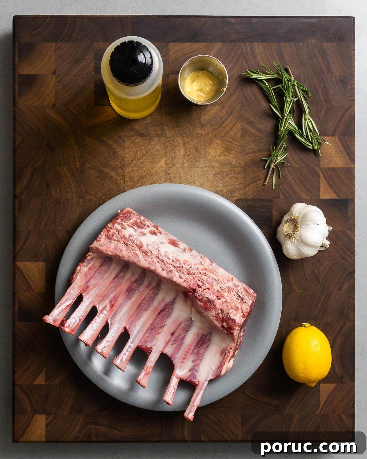 Lemon Garlic Grilled Lamb Rib Chops Recipe for Juicy Flavor 3 Ingredients shown: olive oil, Dijon mustard, rosemary, garlic, lemons, and rack of lamb.