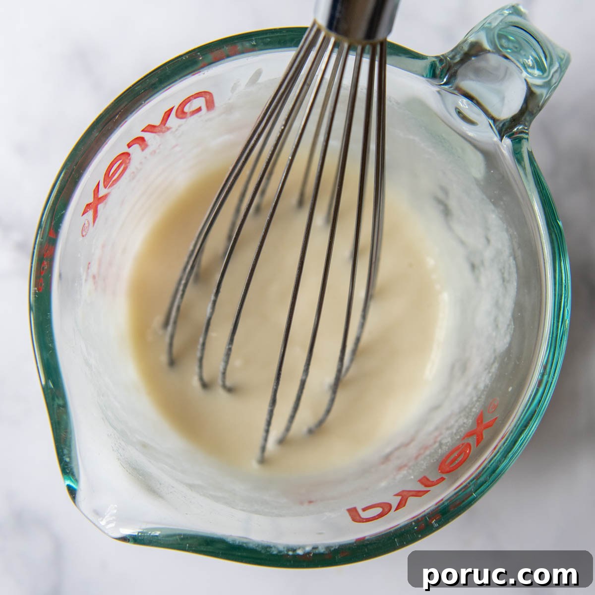 Velvety Gluten-Free Gravy Without Pan Drippings — Thickener Tips 3 a small amount of flour being whisked into broth.