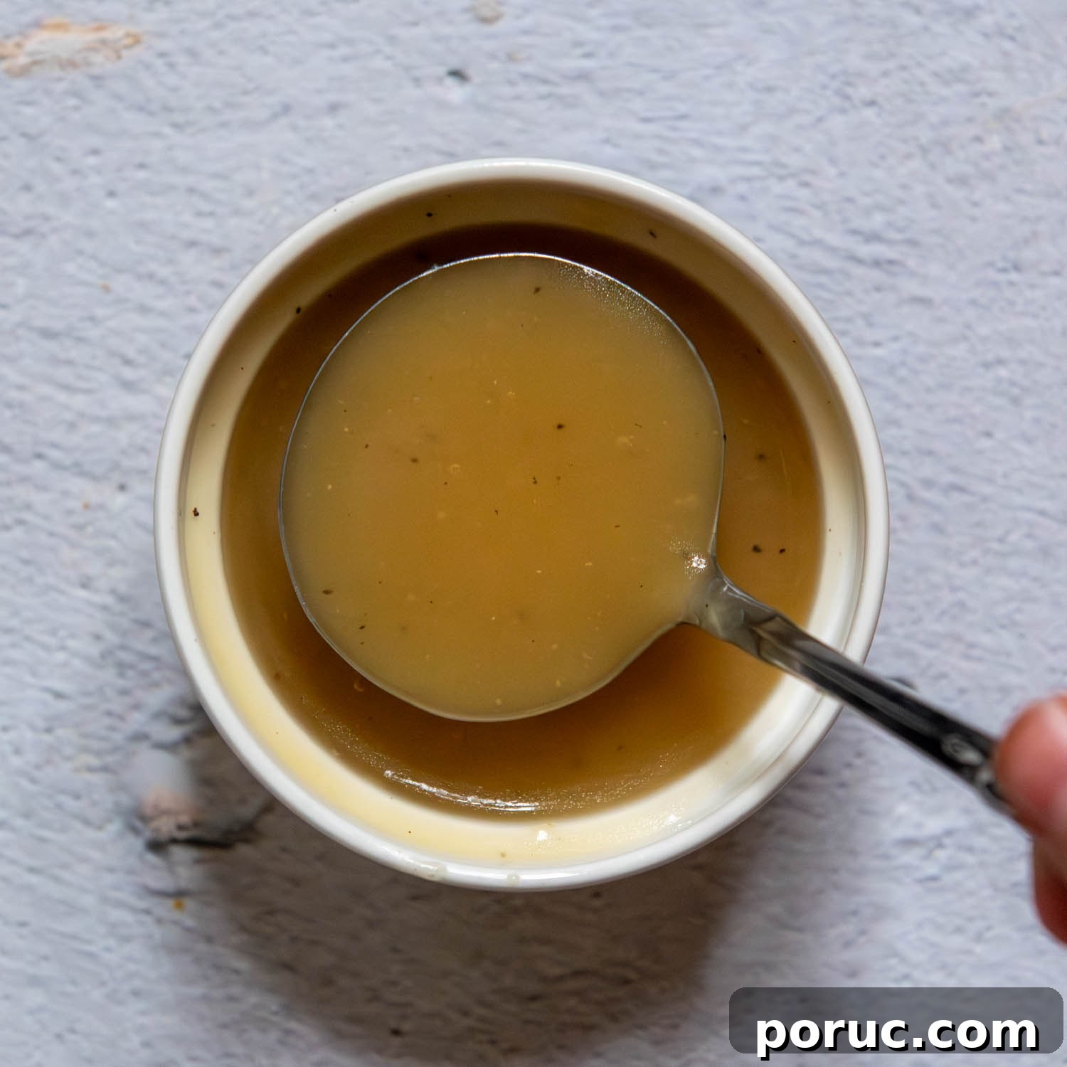 Velvety Gluten-Free Gravy Without Pan Drippings — Thickener Tips 9 small ladle showing consistency of gravy thickened with cornstarch.