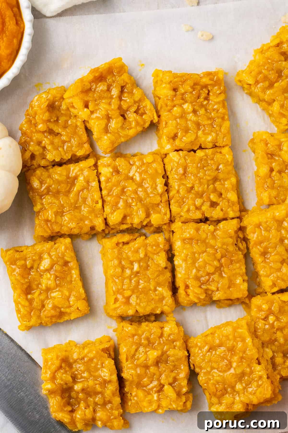 Pumpkin Marshmallow Rice Krispie Treats for Fall Parties 2 Cut up pumpkin Rice Krispie treats on parchment paper.
