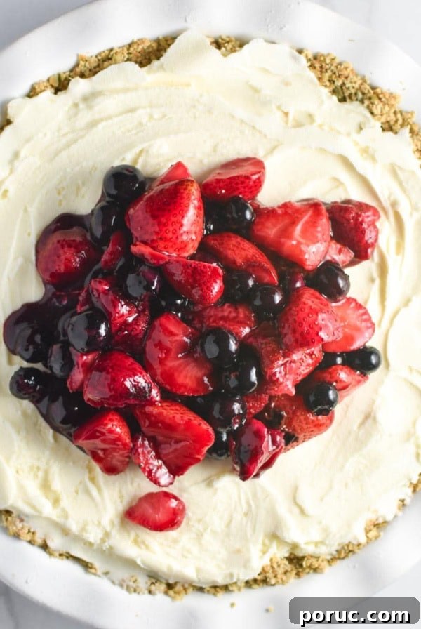 Crustless Blueberry Pie Recipe: Quick, Creamy Summer Dessert 14 Fresh summer berries on top of a vanilla ice cream pie with an oat crust on a white marble table