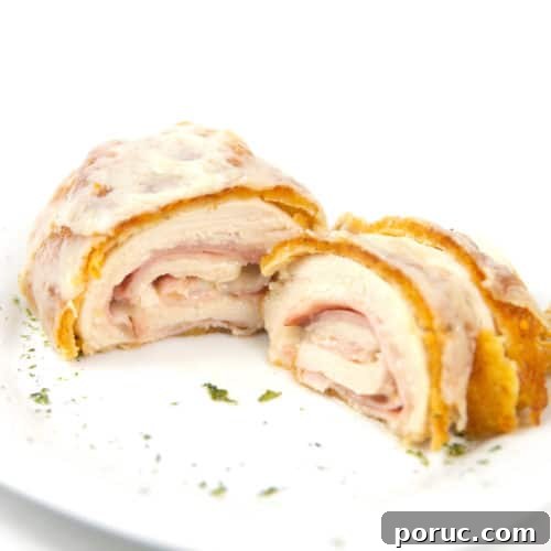 white plate of cut down the middle cordon bleu with ham and cheese inside chicken breast