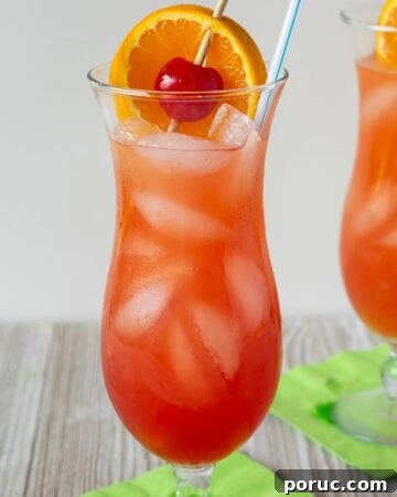 Classic Hurricane Cocktail served with orange slice and cherry garnish in a hurricane glass.