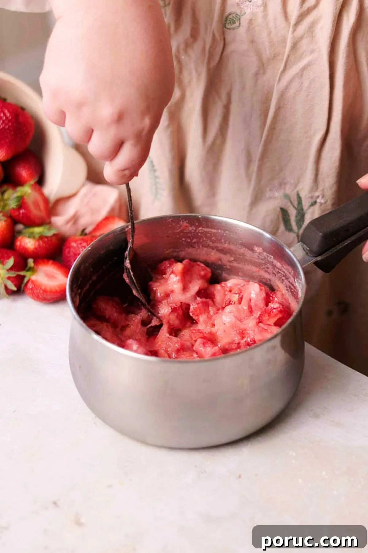 Strawberry Cinnamon Roll Recipe — Soft, Sweet, Homemade Treat 5 stirring uncooked strawberry filling in a saucepan