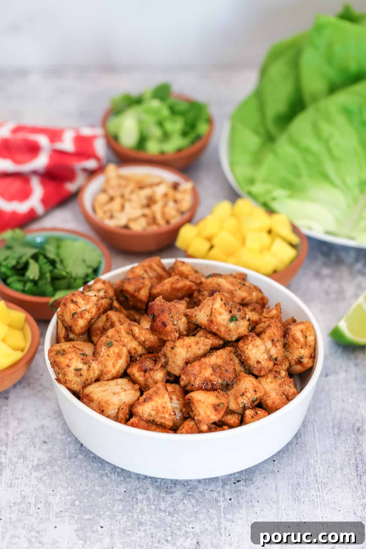 Jamaican Jerk Chicken Lettuce Wraps with Mango Salsa 7 Jerk chicken in a bowl with several smaller sized bowls filled with toppings.