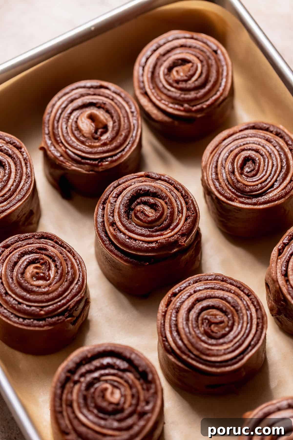 Chewy Cosmic Brownie Roll Recipe with Sprinkle Filling 7 Chocolate dough with brownie filling rolled into tight swirls arranged in a baking pan.