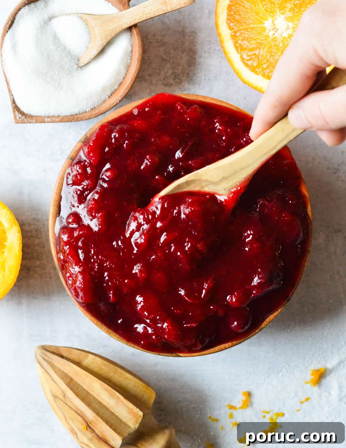 a bowl of cranberry sauce with a wooden spoon in it. 