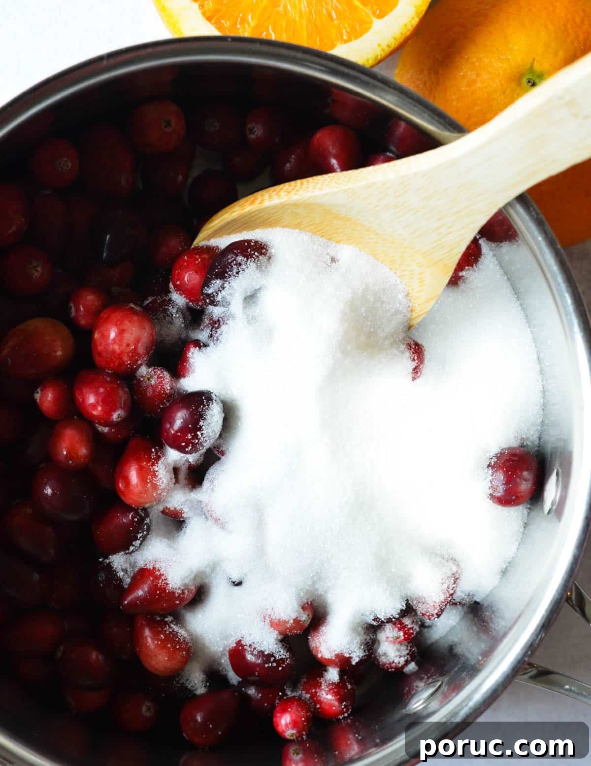 a pot with cranberries and sugar in it. 