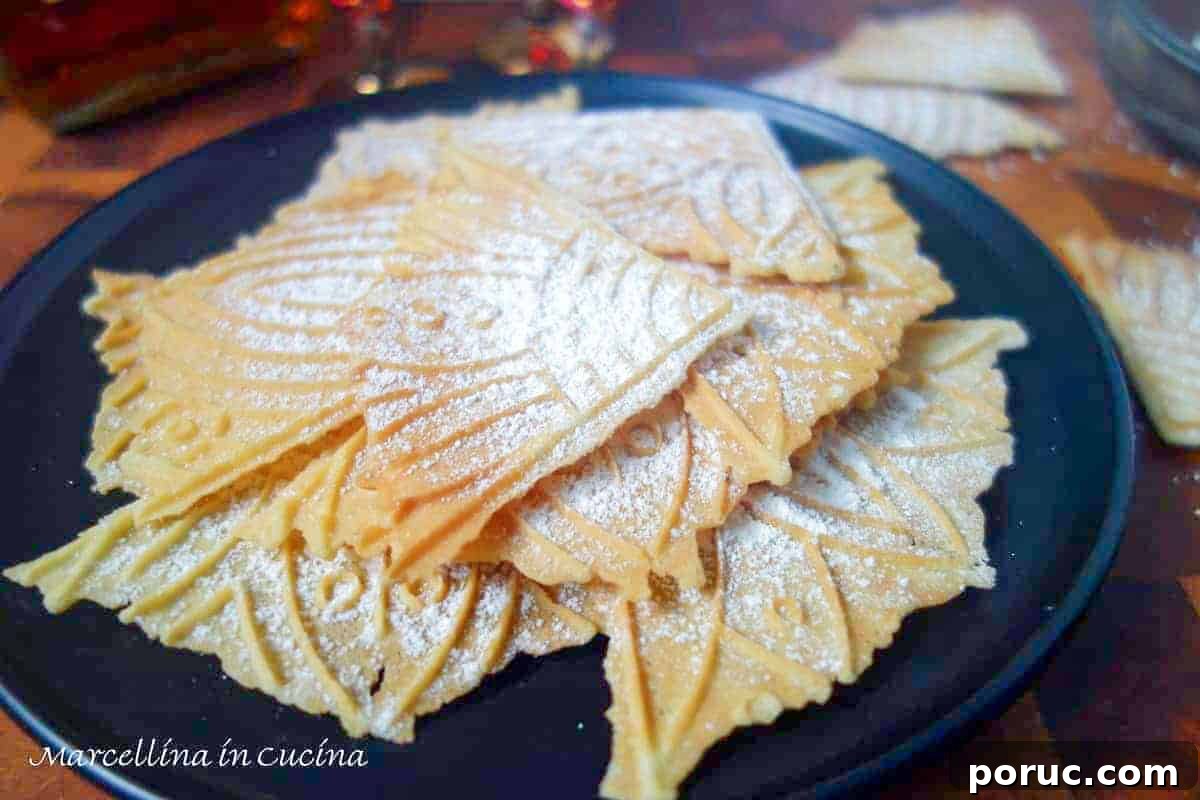 Crisp Lemon Pizzelle Cookies Recipe – Light Citrus Italian Wafers 3 pizzells dusted with powdered sugar on a black plate.
