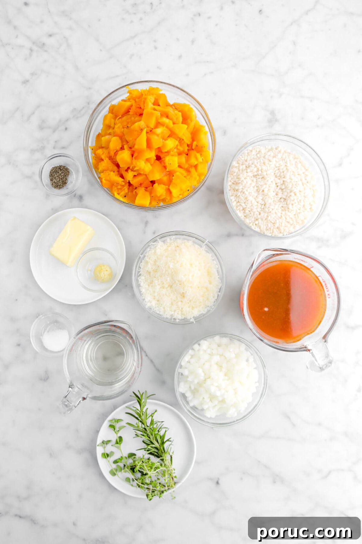 Creamy Roasted Butternut Squash Risotto Recipe 5 ground pepper, chopped butternut squash, arborio rice, butter, minced garlic, grated parmesan, broth, chopped onion, salt, white wine, and herbs on marble surface.