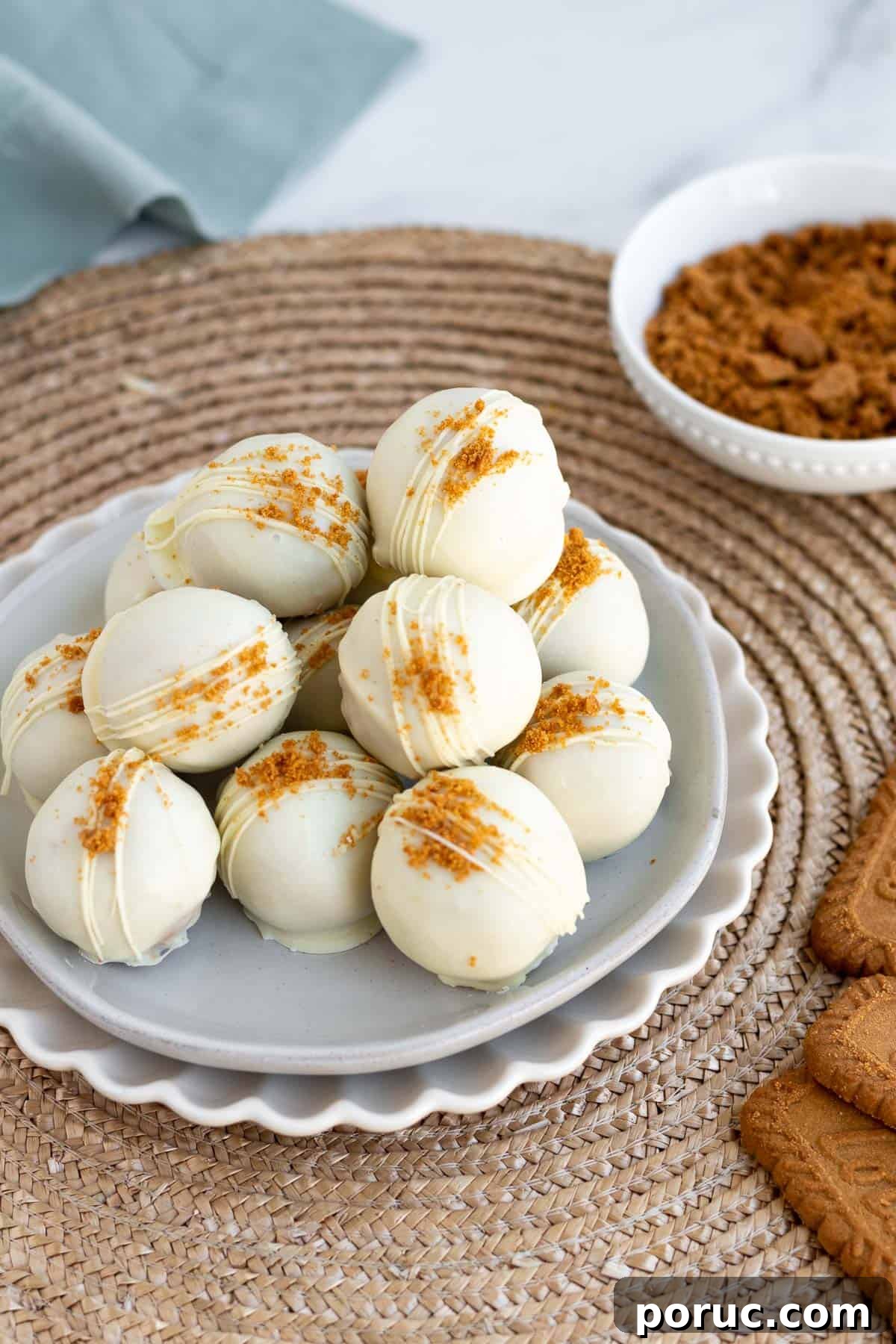 Decadent Biscoff Truffles Recipe: No-Bake Chocolate Treats 6 a pile of white chocolate covered biscoff truffles on a gray plate