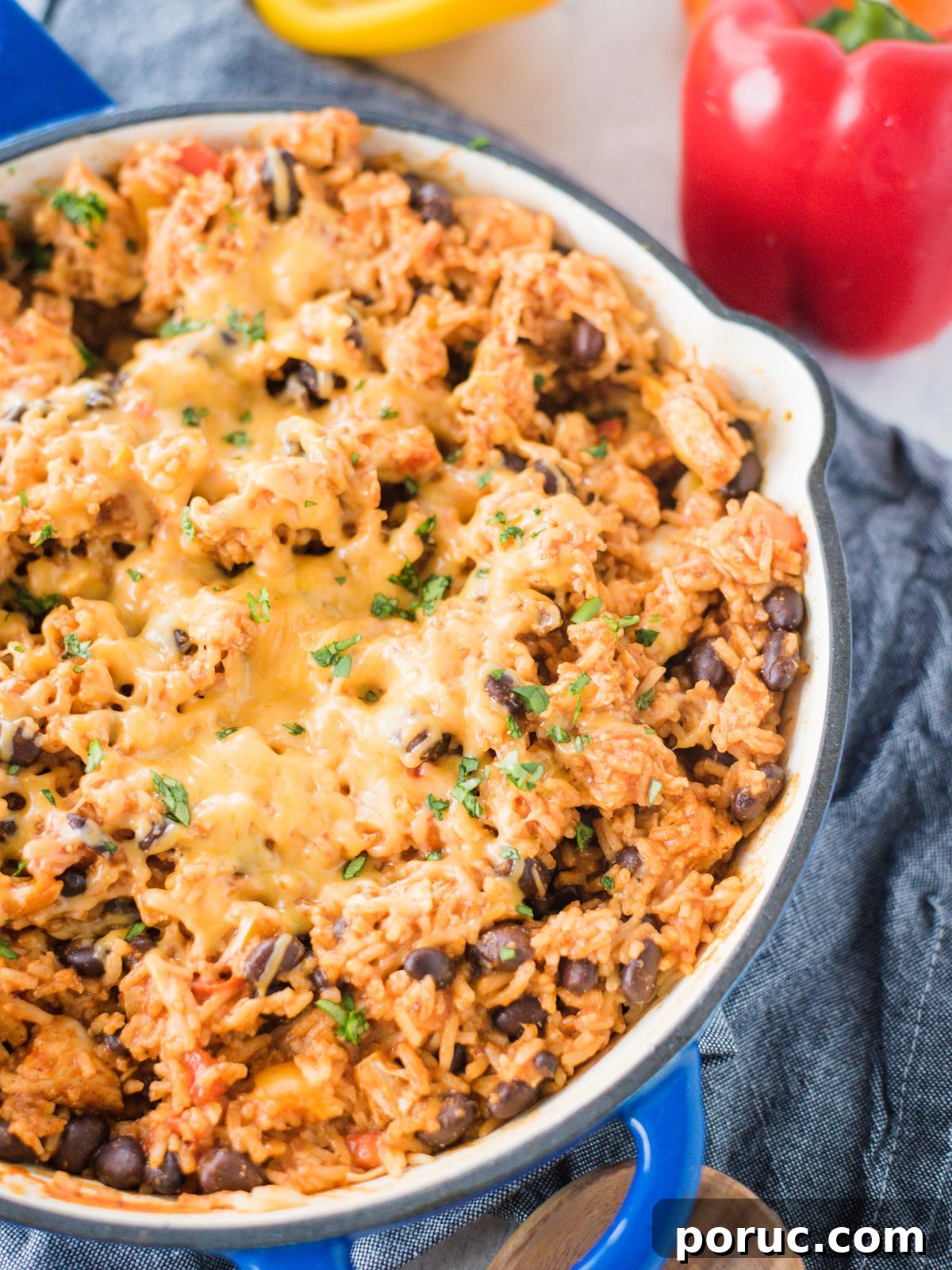 Southwest Chicken Skillet Recipe with Peppers and Black Beans 12 Partial view of a dutch oven filled with Southwest Chicken with melted cheese over the top.