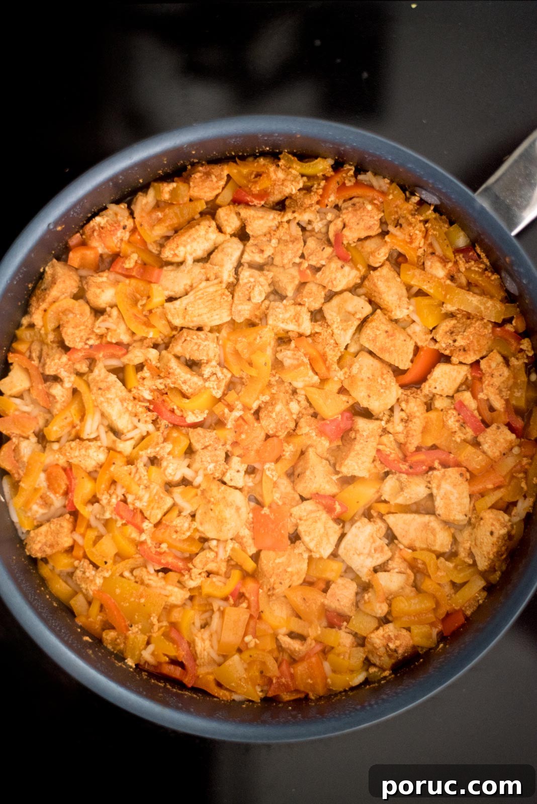 Southwest Chicken Skillet Recipe with Peppers and Black Beans 7 Cooked chicken, bell peppers, and rice in a skillet on the stove.