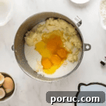 Whipped Cotton Candy Cake Recipe for Celebratory Parties 7 eggs and milk added to cake batter in a stainless bowl.