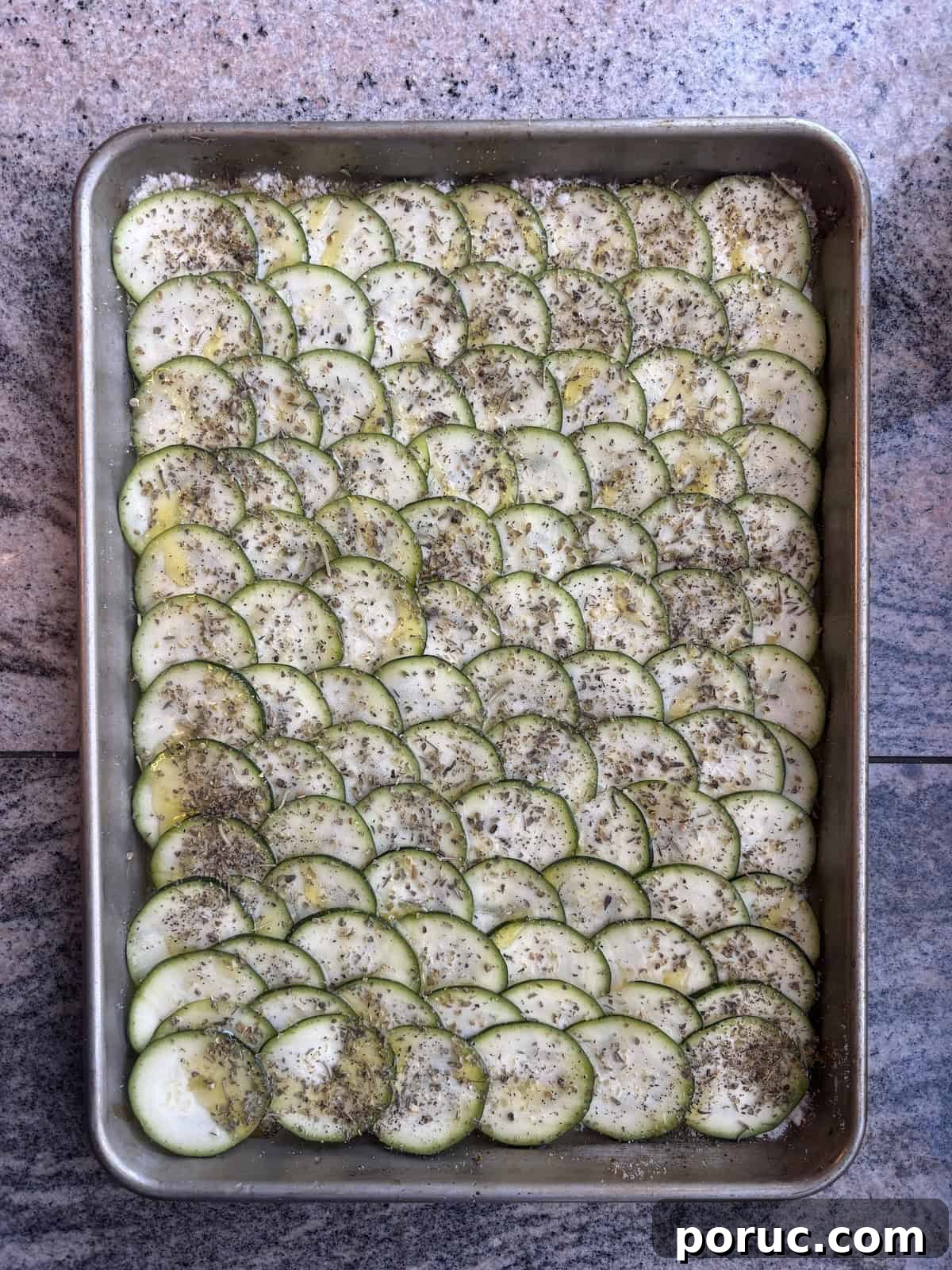 Crispy Parmesan Baked Zucchini Slices 5 A baking sheet with thinly sliced zucchini seasoned with italian seaoning, salt and pepper, laying of top of grated parmesan cheese