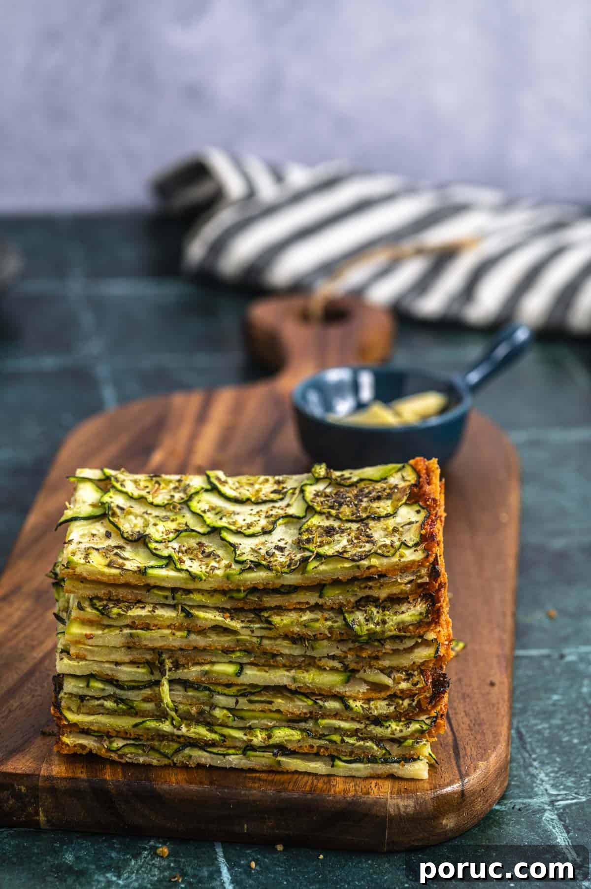 Crispy Parmesan Baked Zucchini Slices 7 Piled slices of baked parmesan zucchini on a wood board