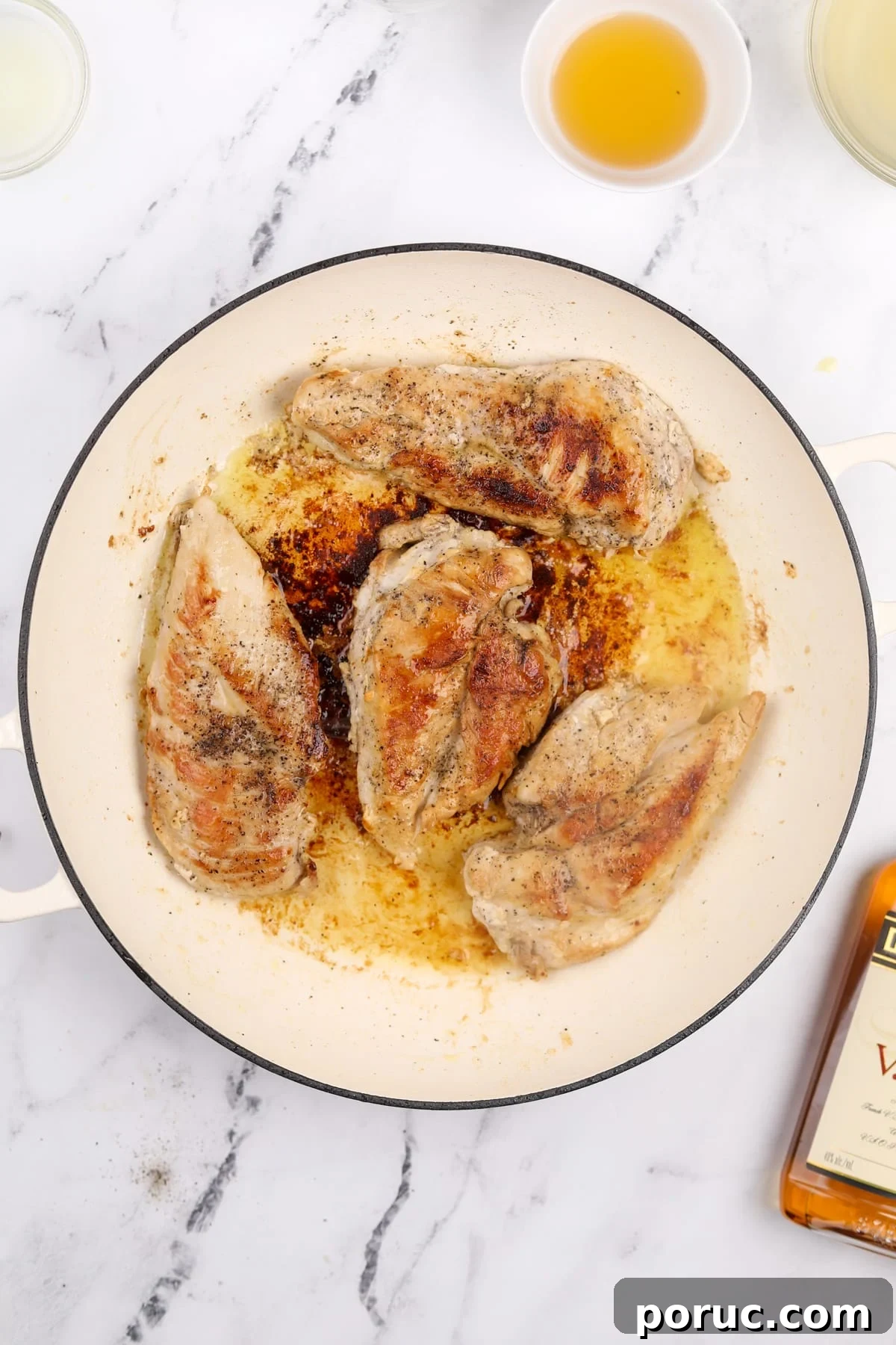 Chicken breasts that have been browned in a skillet.