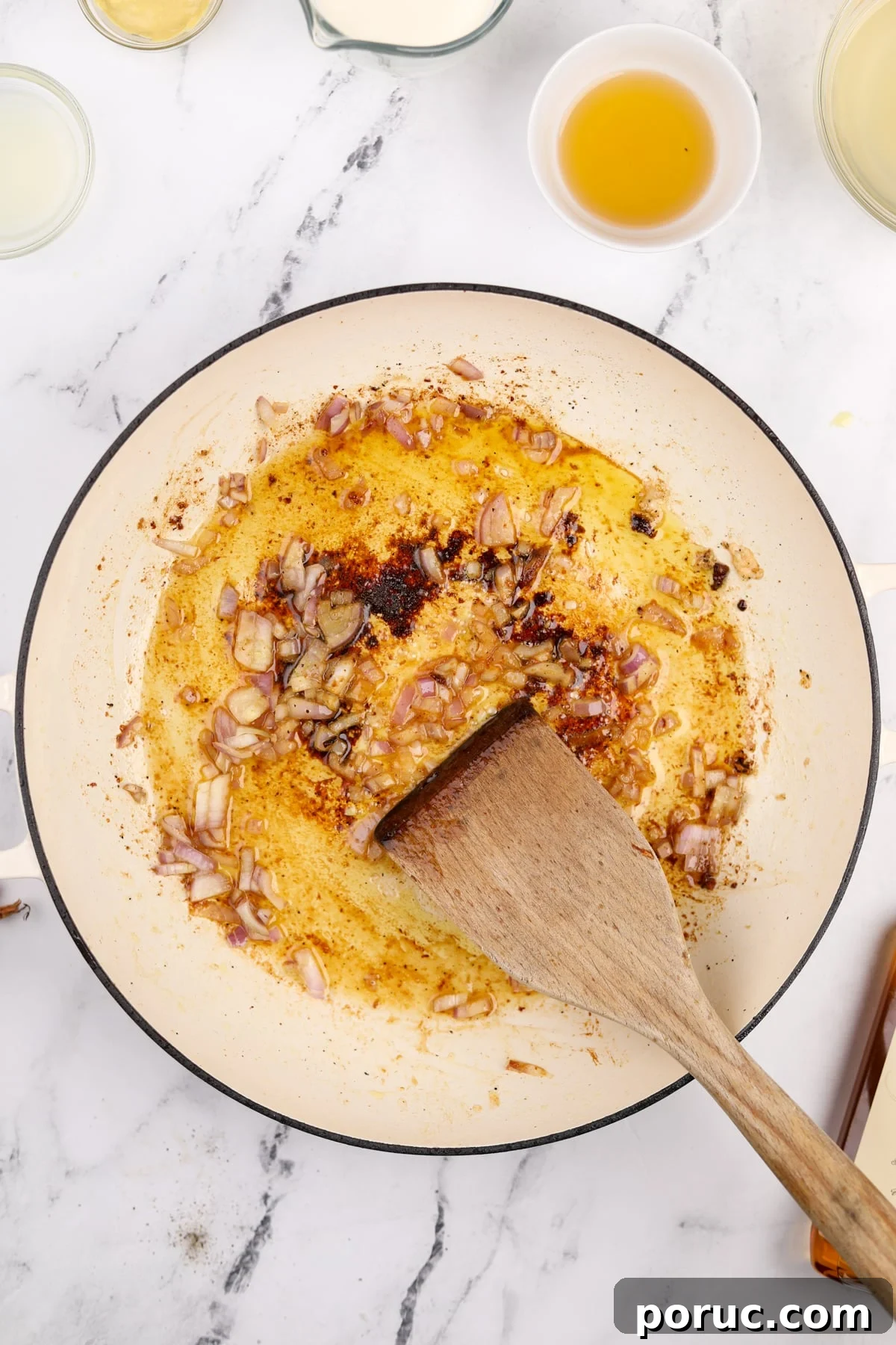 Cooking a shallot in a skillet with oil and butter.