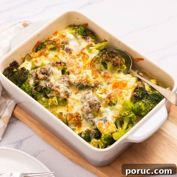 An image of broccoli cheese casserole served on a table with a spoon on the right side.