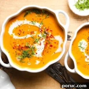 Creamy Pumpkin and Carrot Soup Recipe with Warm Spices 5 Creamy pumpkin carrot soup garnished with herbs and spices in white bowls.