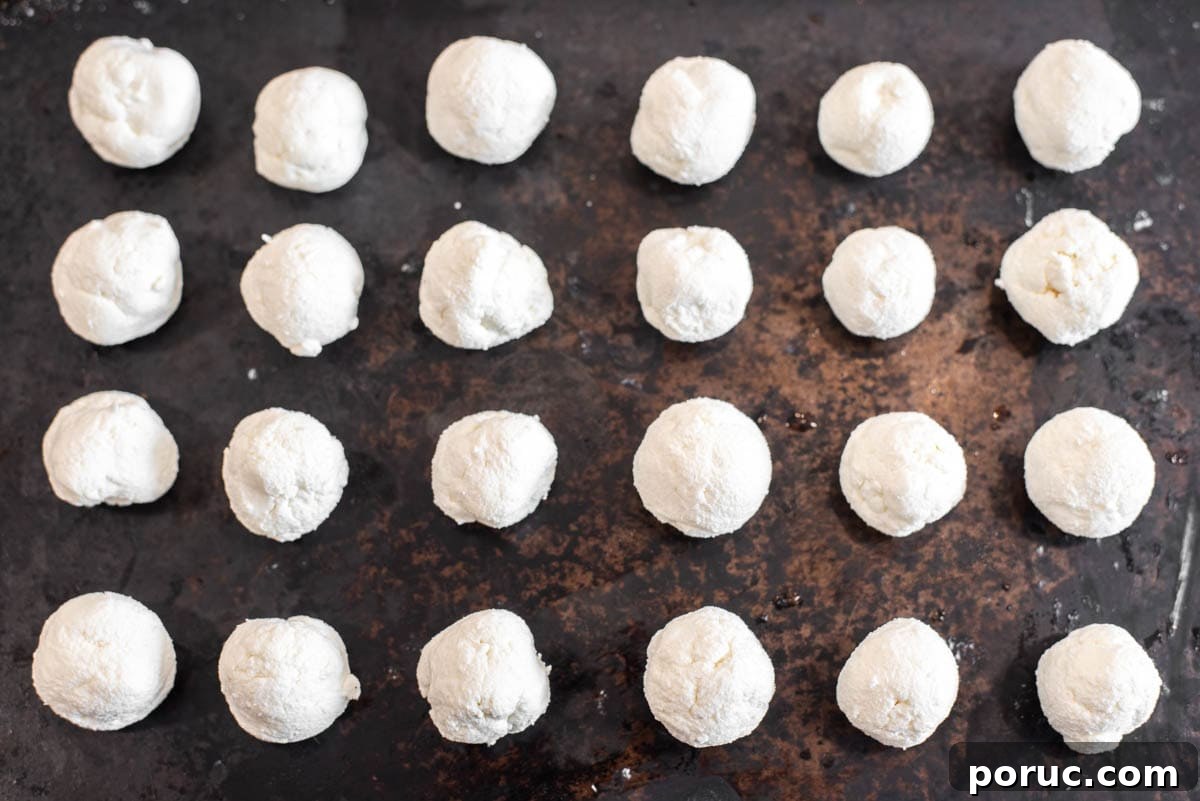 Crispy Fried Goat Cheese Balls with Honey Dip 4 Goat cheese rolled in balls on baking sheet.