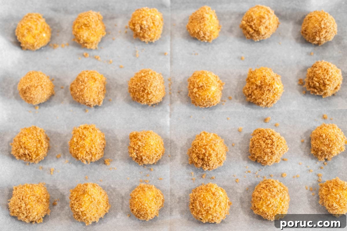 Crispy Fried Goat Cheese Balls with Honey Dip 8 Goat cheese balls coated in breadcrumbs on parchment-lined baking sheet.