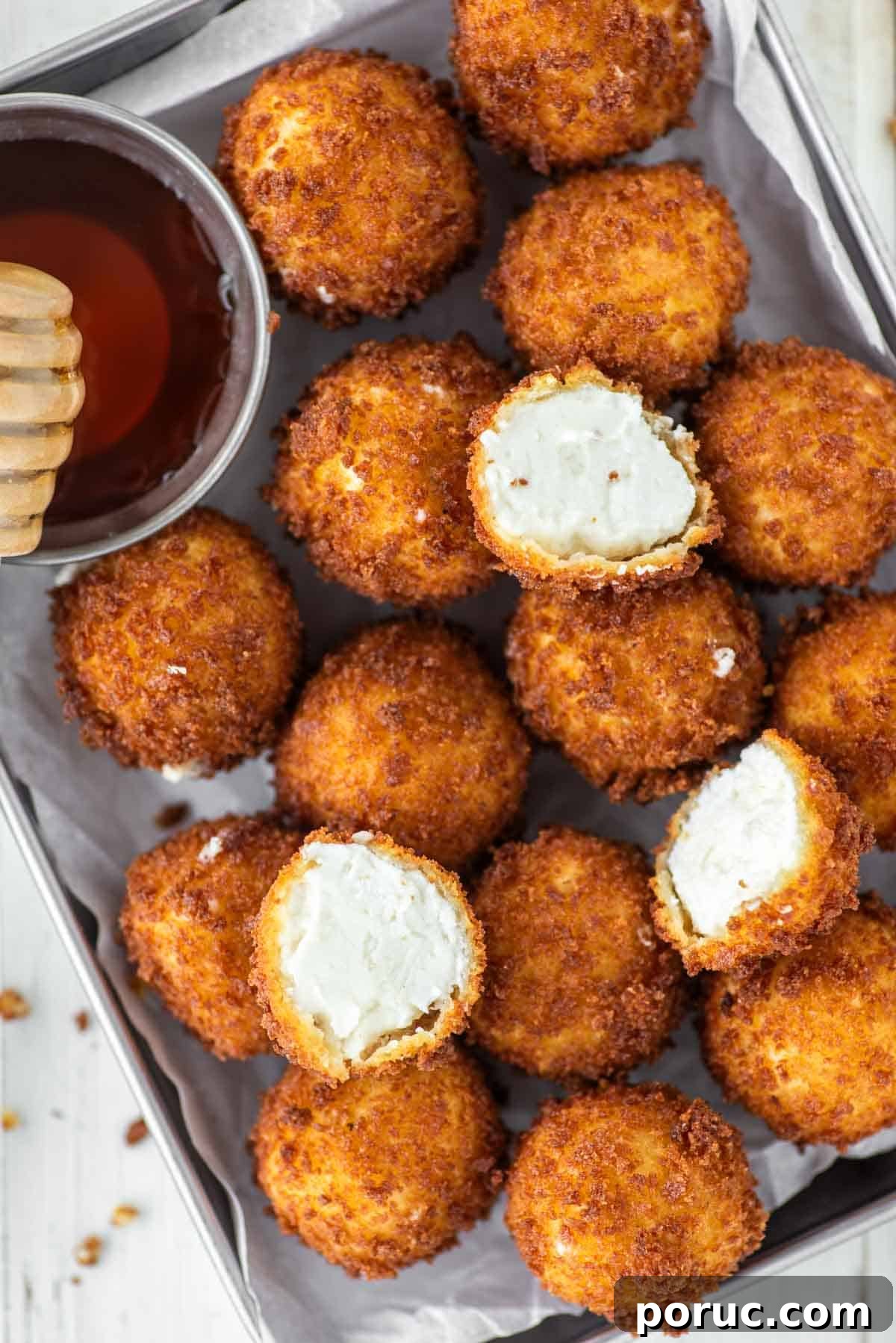 Crispy Fried Goat Cheese Balls with Honey Dip 10 Fried goat cheese balls in metal pan with honey.