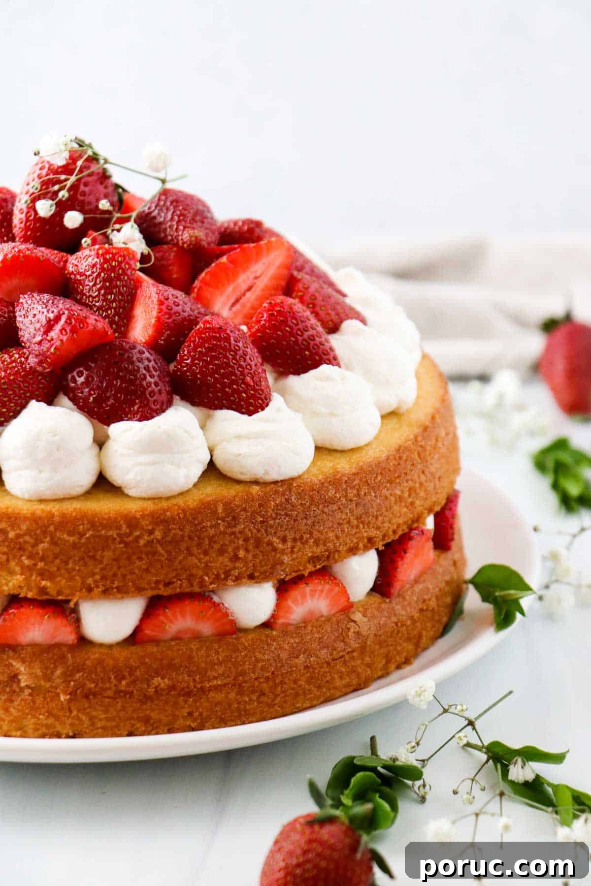 Vanilla Layer Cake with Strawberry Filling — Swedish Midsummer Cake 2 Layer cake topped with whipped cream and fresh strawberries next to flowers and strawberries.