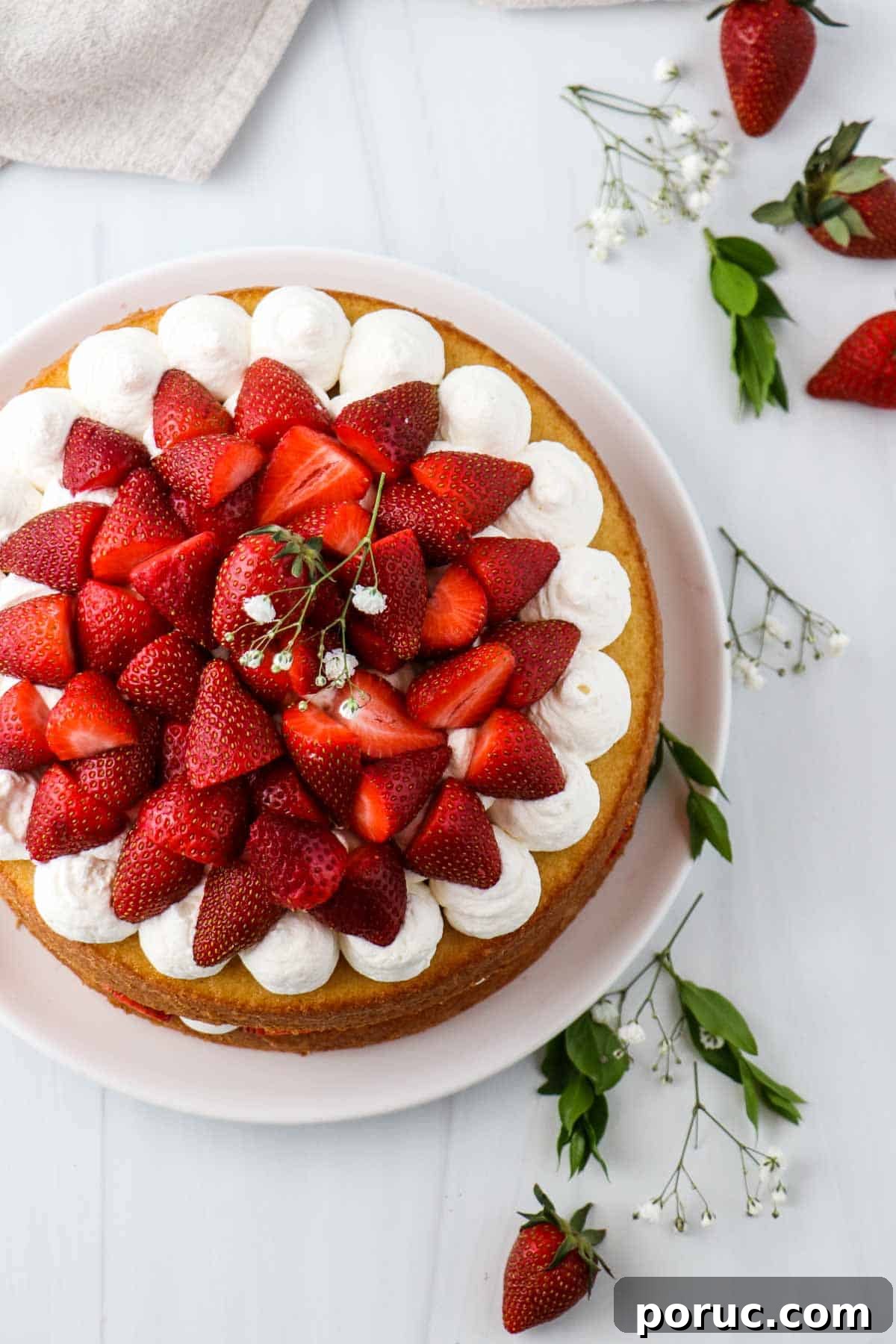 Vanilla Layer Cake with Strawberry Filling — Swedish Midsummer Cake 18 Overhead view of a cake topped with strawberries.