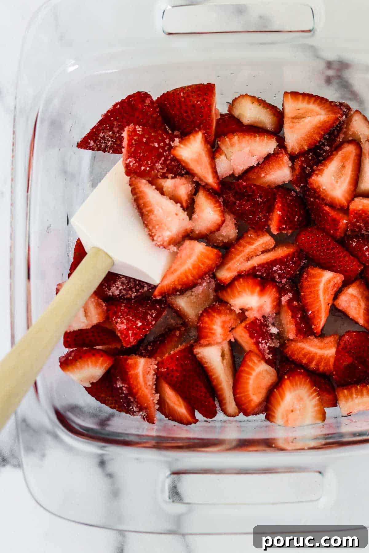 Vanilla Layer Cake with Strawberry Filling — Swedish Midsummer Cake 7 Strawberries and sugar in a glass baking dish with a rubber spatula.