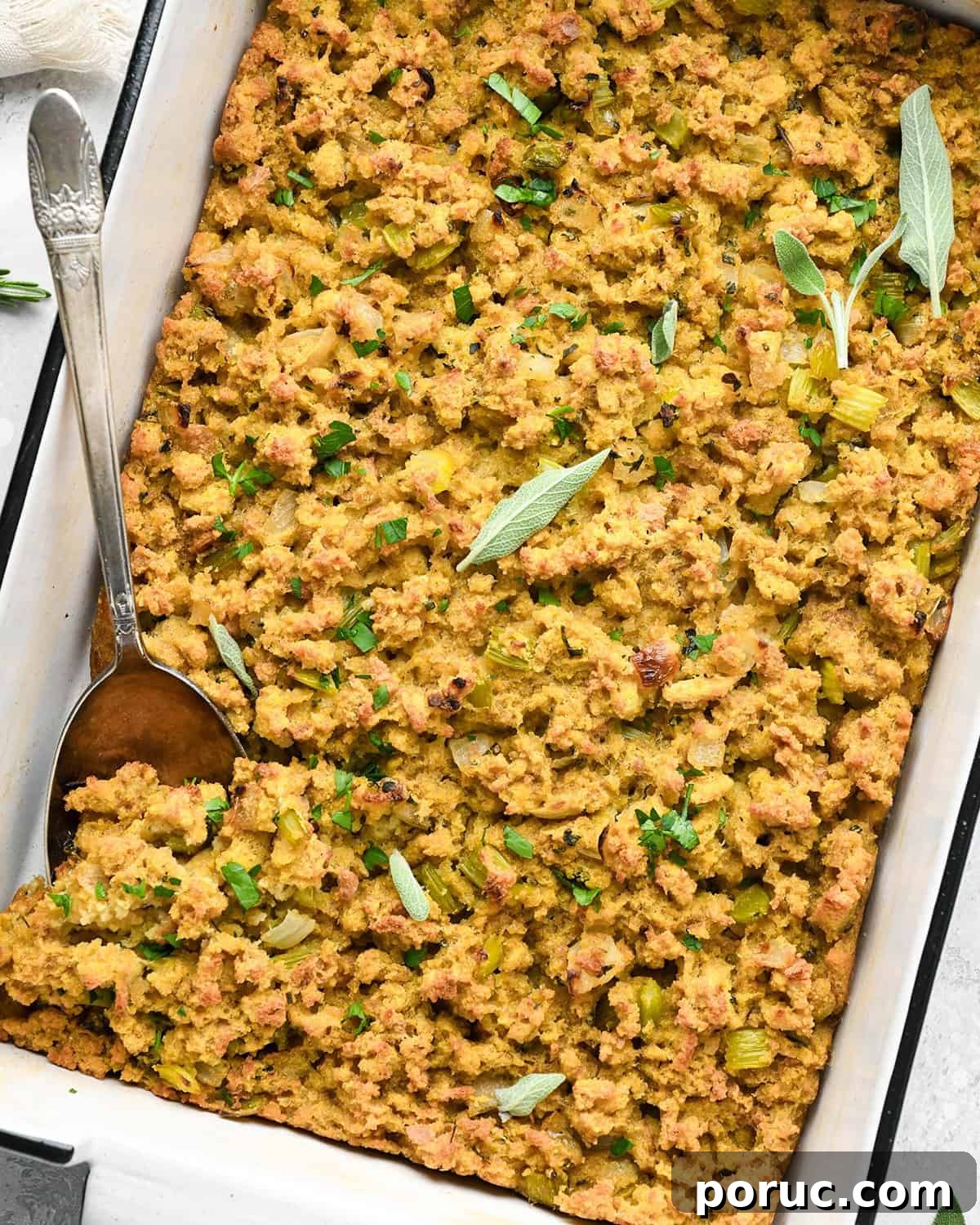 Southern Cornbread Dressing Recipe — Classic Holiday Side Dish 3 Cornbread Dressing in a baking dish topped with fresh herbs