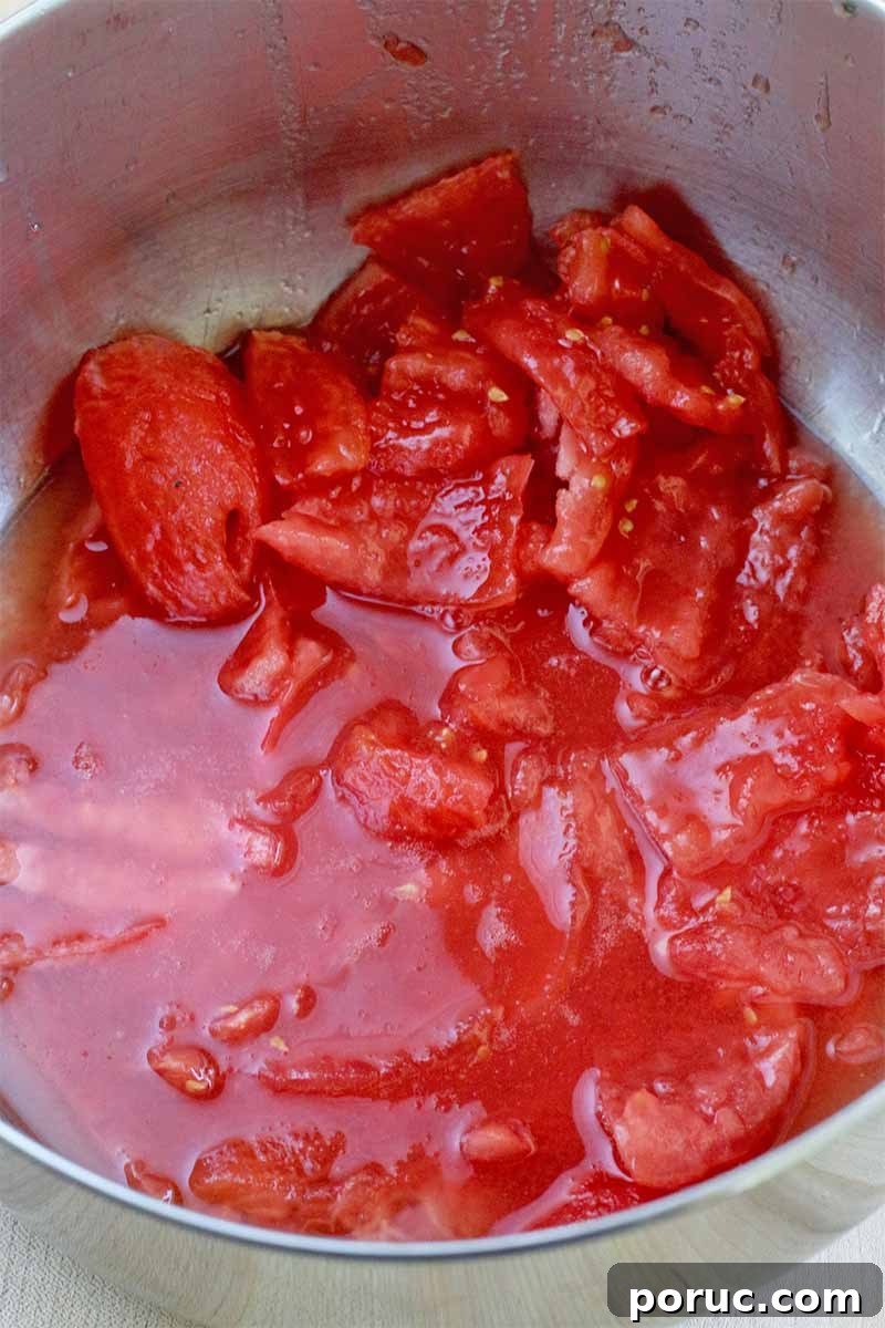 Creamy Tomato Basil Bisque That Elevates Classic Comfort Food 11 Closeup of peeled and chopped tomatoes and their juices, in a stock pot.
