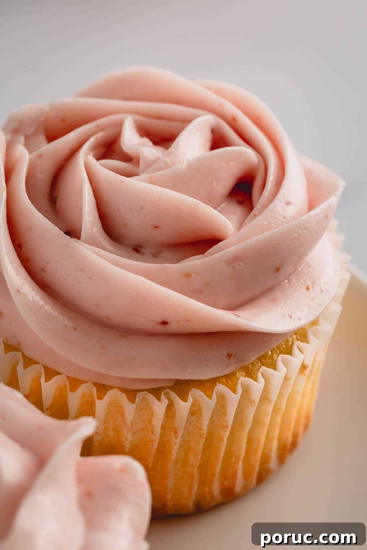 A vanilla cupcake topped with raspberry buttercream.