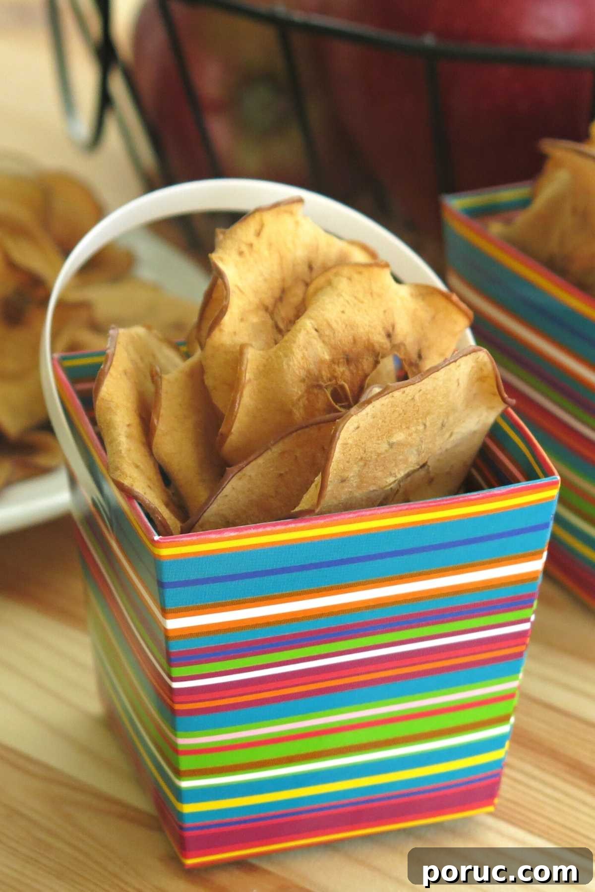 Crispy Oven-Dried Apple Chips Recipe for Snacking 6 Baked apple chips in a colorful serving box.