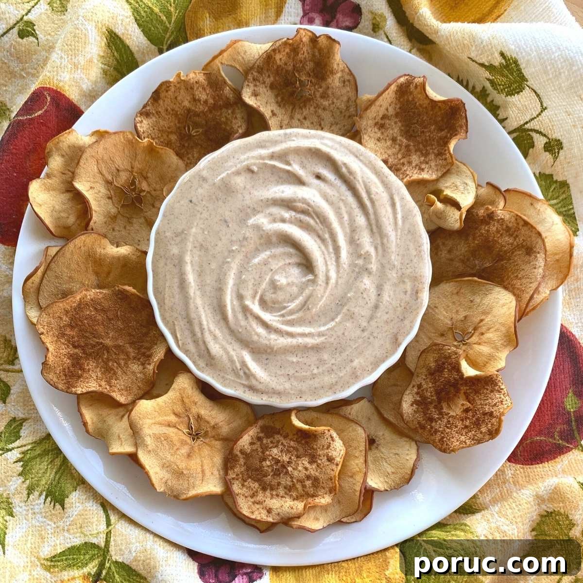 Crispy Oven-Dried Apple Chips Recipe for Snacking 7 Bowl of almond butter Greek yogurt dip surrounded by dried apple chips.