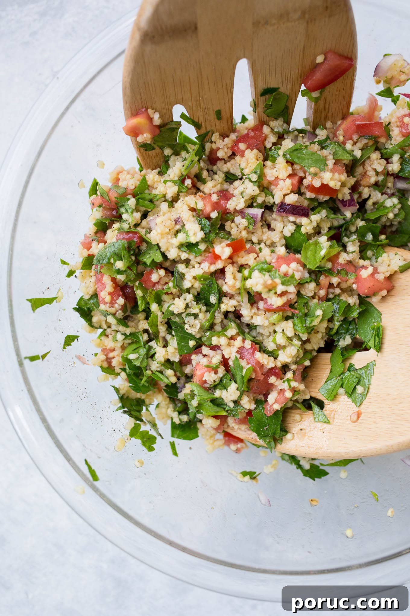 Gluten-Free Vegan Millet Tabbouleh Salad Recipe 4 Tabbouleh salad being mixed with salad tongs.