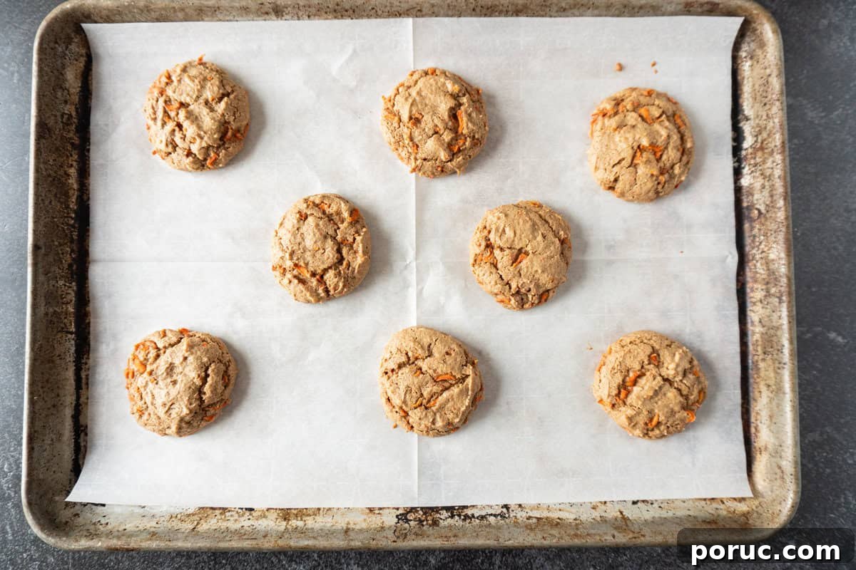 carrot cake cookies baked on parchment lined baking sheet.
