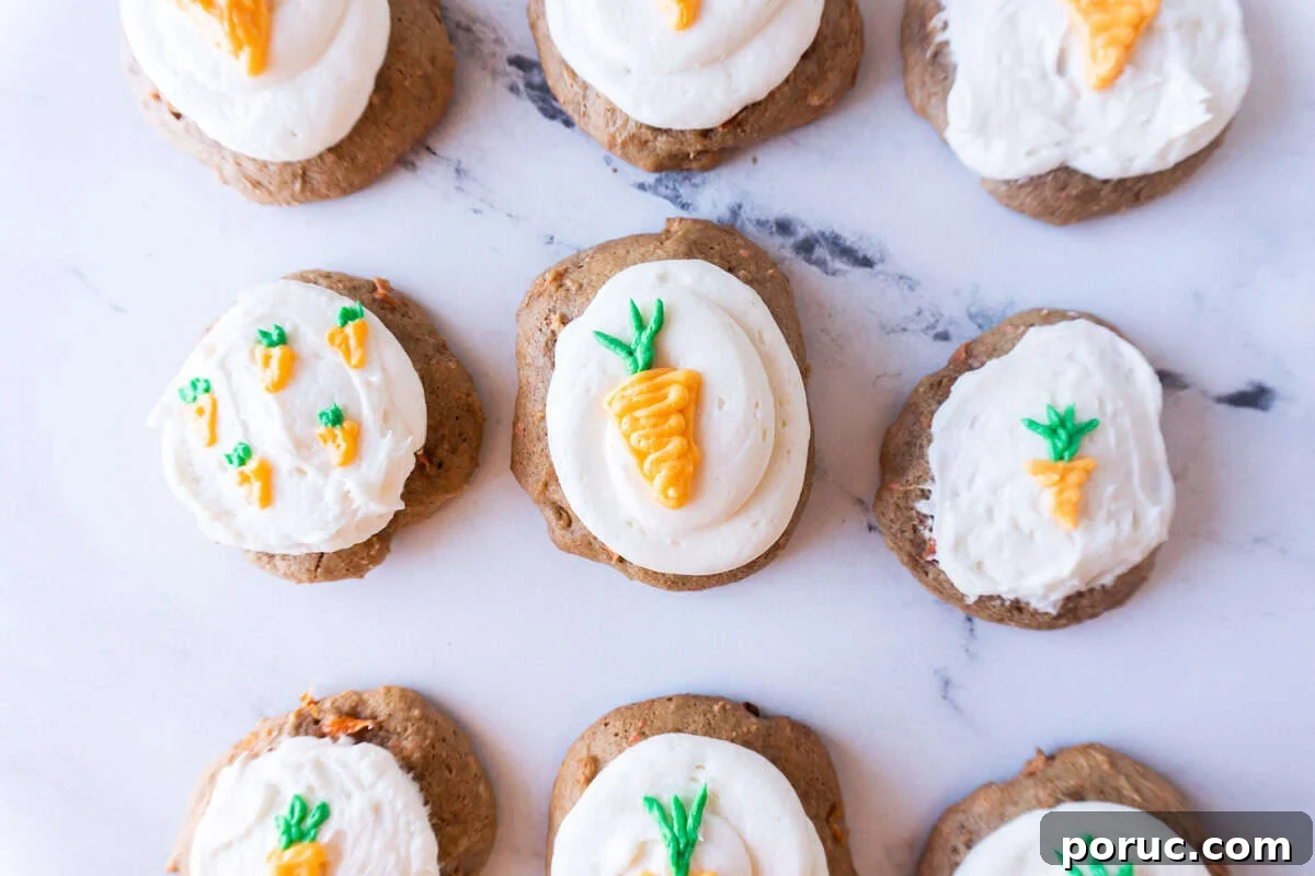 carrot cake cookies frosted with cream cheese frosting and decorated with little frosted carrots.