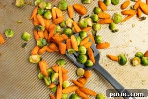 Spicy Honey-Roasted Brussels Sprouts and Carrots 16 This is a picture of the veggies on a baking tray tossed in hot honey.